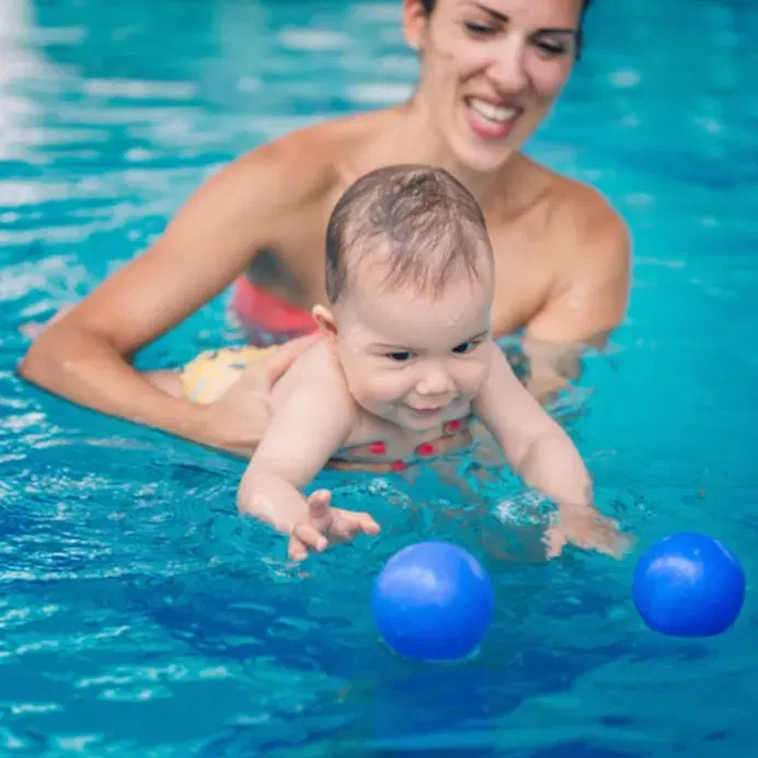 Baby boy swimming with mother Baby boy swimming with mother