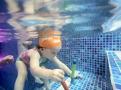 toddler retrieving dive sticks underwater toddler retrieving dive sticks underwater